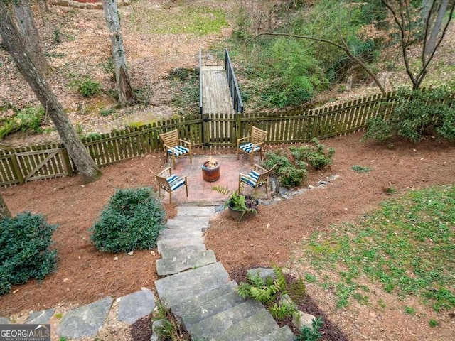 view of yard with a patio area, a fenced backyard, and a fire pit