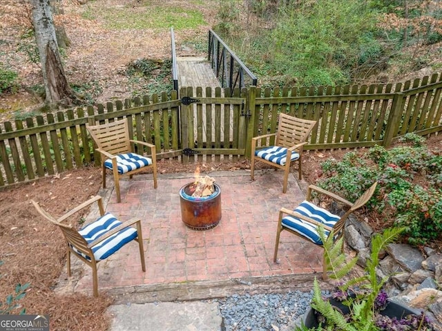 view of patio with an outdoor fire pit and fence