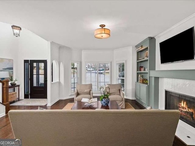 living room with built in features, dark wood-style flooring, a fireplace, and baseboards