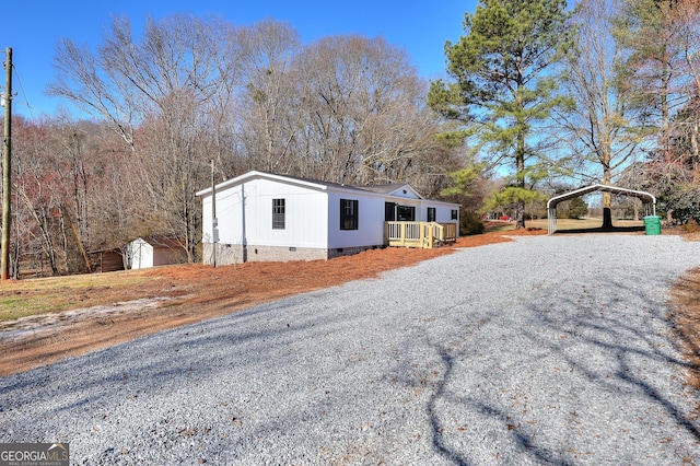 view of front of home featuring an outdoor structure, driveway, crawl space, a detached carport, and a storage unit