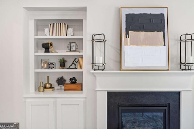 room details featuring built in features and a glass covered fireplace