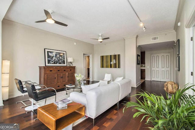 living room featuring visible vents, baseboards, a ceiling fan, wood finished floors, and crown molding