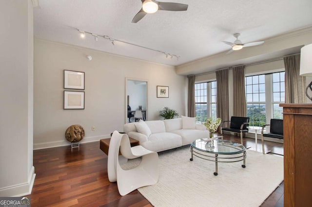 living room featuring baseboards, ceiling fan, ornamental molding, wood finished floors, and a textured ceiling