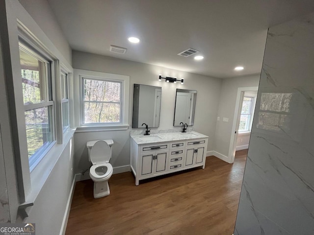 full bathroom with a wealth of natural light, visible vents, baseboards, and wood finished floors