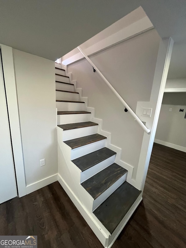 stairway featuring baseboards and wood finished floors