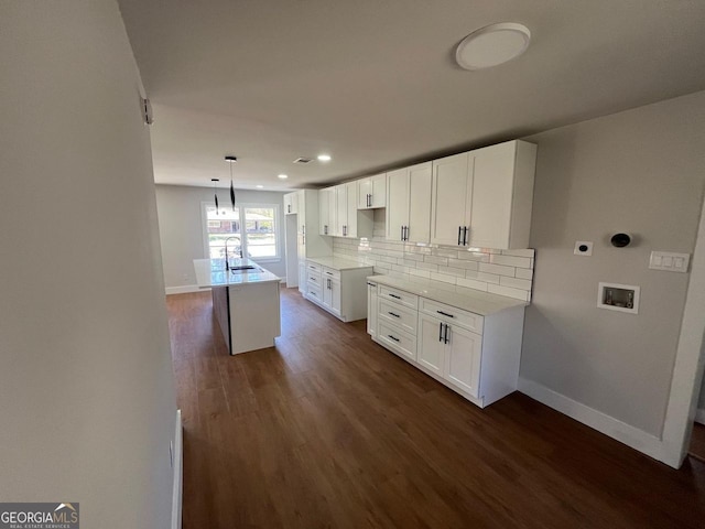 kitchen featuring dark wood finished floors, white cabinets, baseboards, and tasteful backsplash