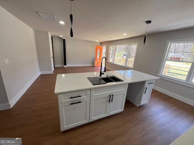 kitchen with dark wood-style flooring, a sink, white cabinets, decorative light fixtures, and open floor plan