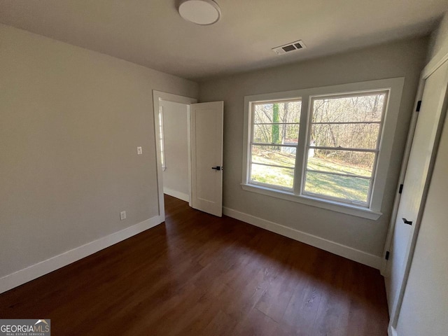 interior space with visible vents, baseboards, and dark wood-style flooring