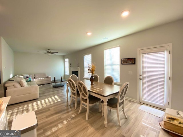 dining space with visible vents, ceiling fan, light wood-type flooring, a fireplace, and recessed lighting