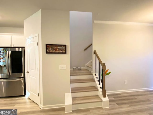 stairway with baseboards and wood finished floors