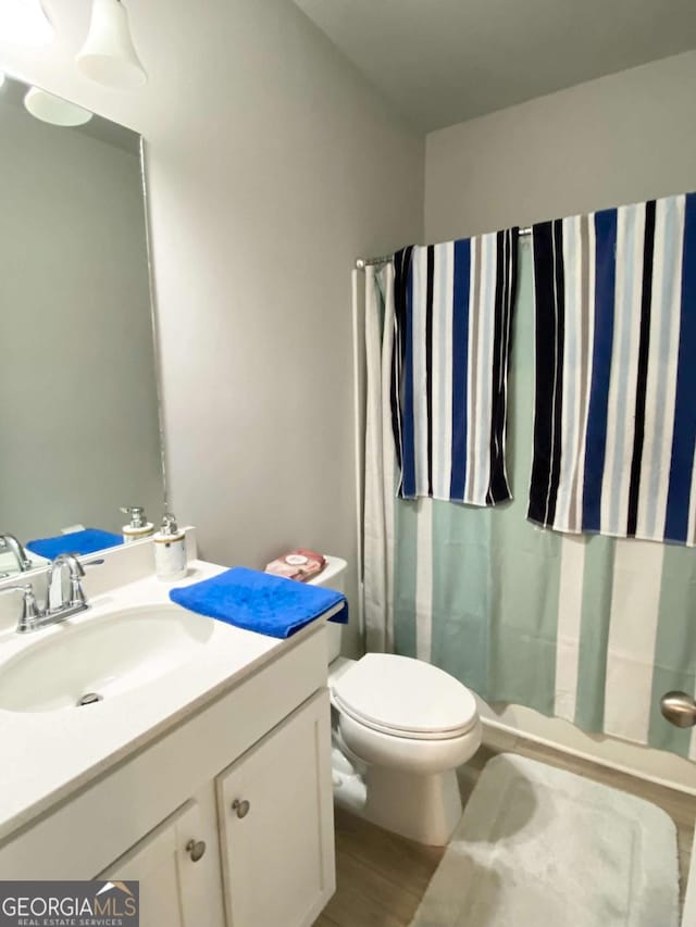 full bath featuring vanity, toilet, and wood finished floors