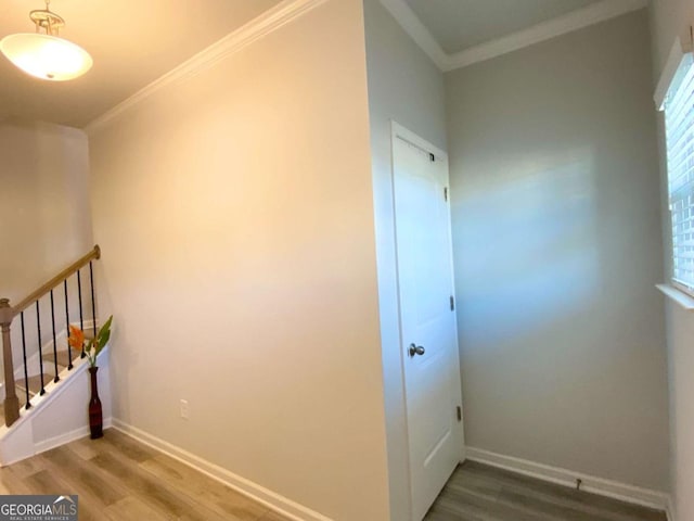 hallway with baseboards, ornamental molding, and wood finished floors