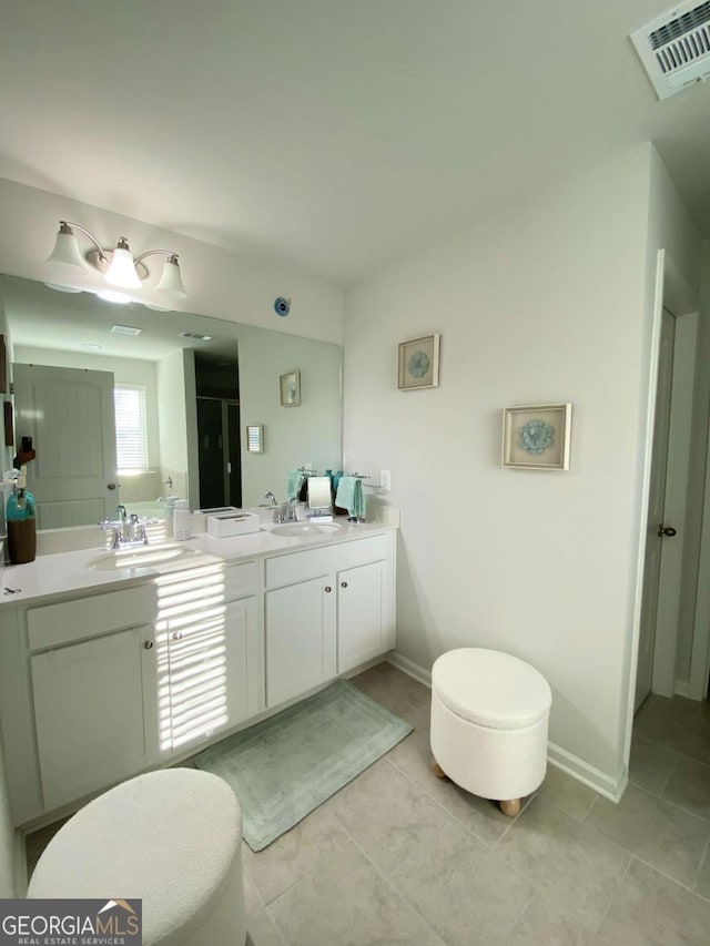 bathroom featuring visible vents, a shower stall, vanity, baseboards, and tile patterned floors