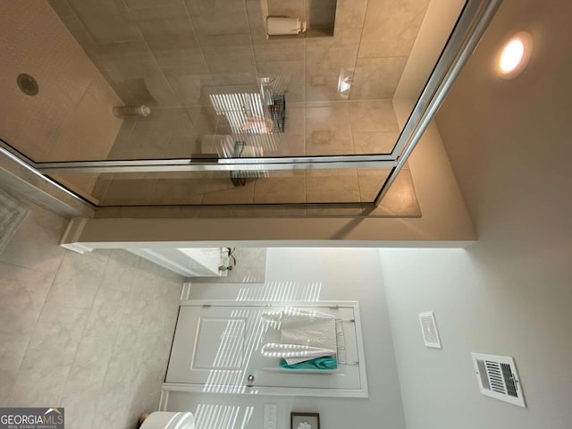 bathroom featuring visible vents and a tile shower