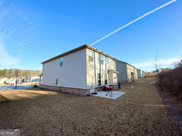 view of side of property featuring a yard and a patio