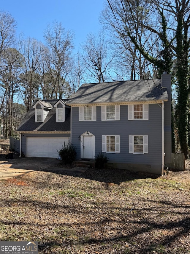 colonial home with crawl space, an attached garage, a chimney, and concrete driveway