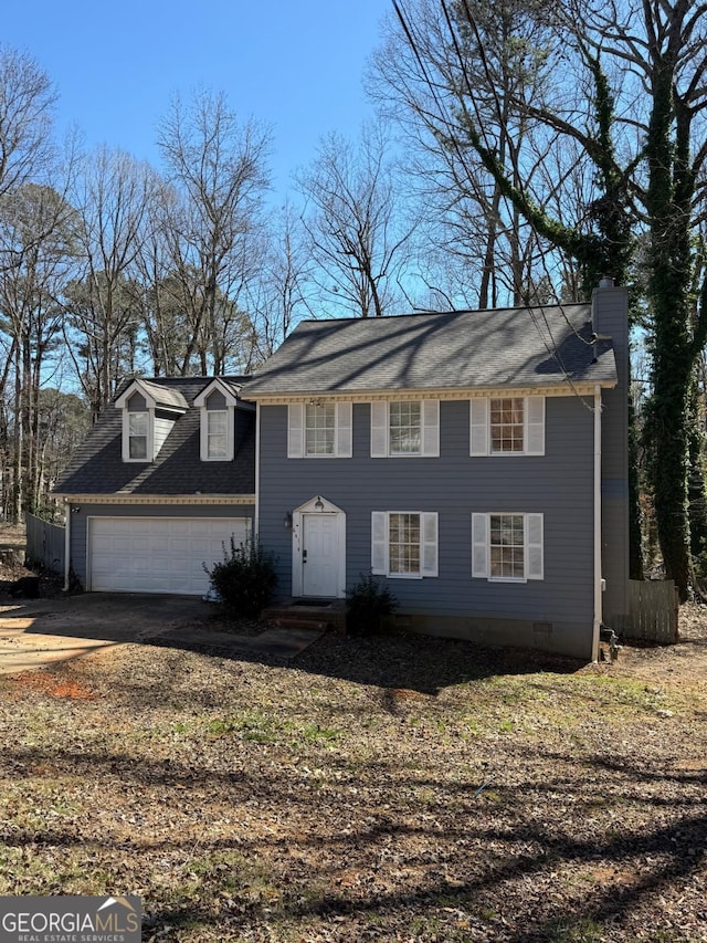 colonial home with a garage, crawl space, driveway, and a chimney