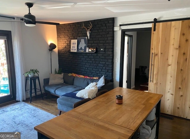 living room featuring a barn door and wood finished floors