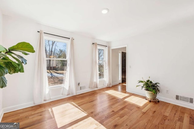 interior space featuring baseboards, visible vents, and wood finished floors