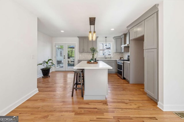 kitchen with tasteful backsplash, visible vents, gray cabinets, french doors, and double oven range