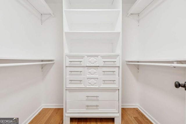 walk in closet with wood finished floors