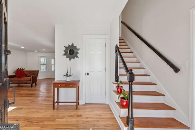 entrance foyer with light wood-style flooring, stairway, baseboards, and recessed lighting