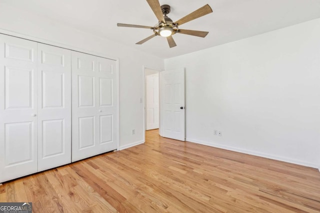 unfurnished bedroom with a closet, ceiling fan, light wood-style flooring, and baseboards