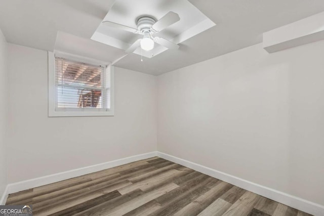 empty room with ceiling fan, wood finished floors, and baseboards