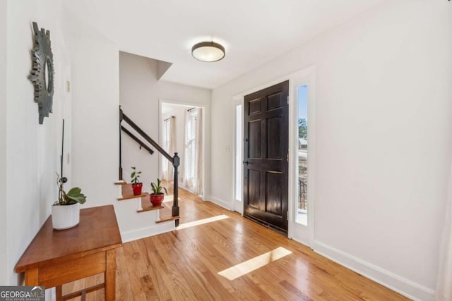 entryway featuring stairway, baseboards, and wood finished floors