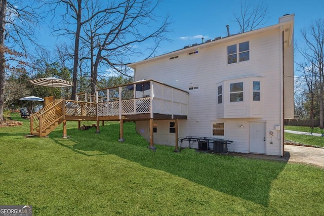 rear view of property with a deck, a yard, stairway, and a chimney