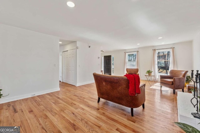 living area with light wood-type flooring, baseboards, and recessed lighting