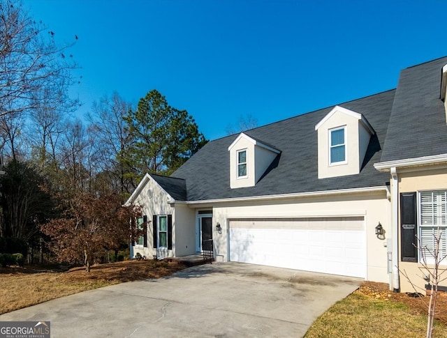 view of front facade featuring concrete driveway, an attached garage, and stucco siding