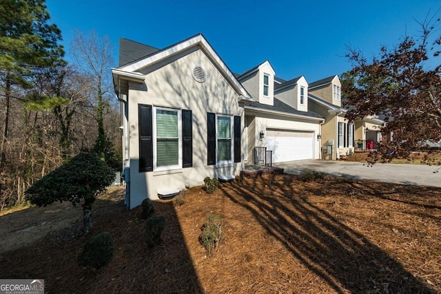 view of front of house featuring a garage, concrete driveway, and stucco siding