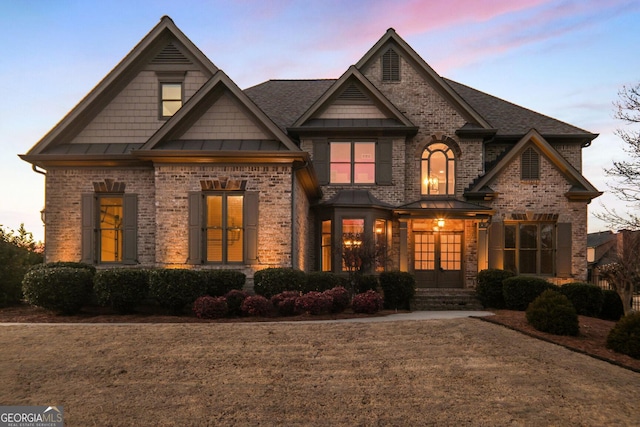 view of front of house with french doors, a standing seam roof, and brick siding