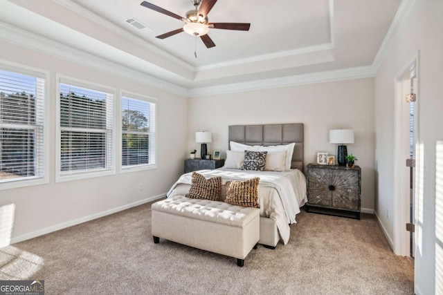 bedroom with light colored carpet, a raised ceiling, visible vents, and baseboards