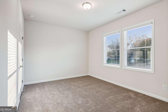 empty room featuring baseboards, visible vents, and carpet flooring