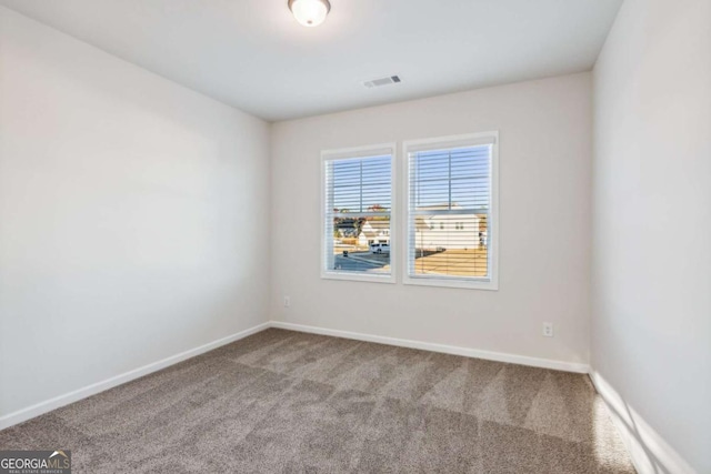 carpeted empty room with visible vents and baseboards