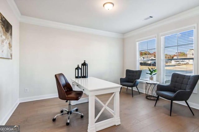 office with baseboards, visible vents, wood finished floors, and ornamental molding