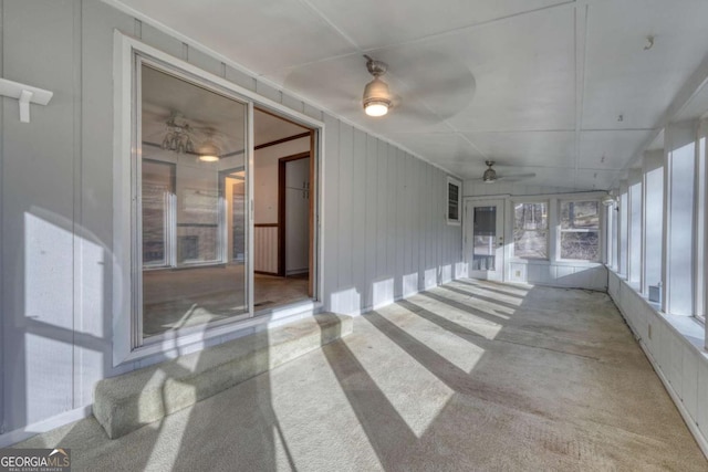 unfurnished sunroom featuring a ceiling fan