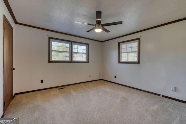 unfurnished room with light carpet, crown molding, a textured ceiling, and baseboards