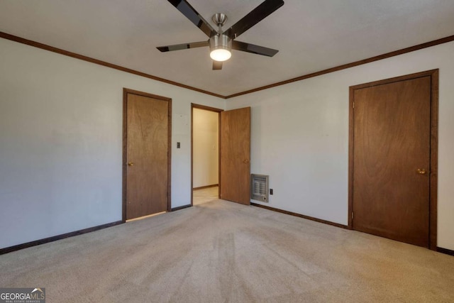 unfurnished bedroom featuring baseboards, a ceiling fan, ornamental molding, heating unit, and carpet floors