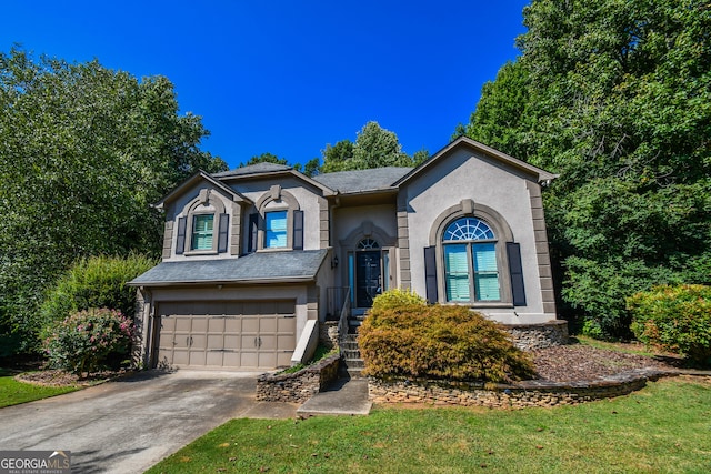 view of front of property featuring driveway, an attached garage, and stucco siding