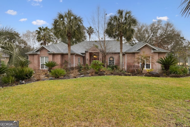 view of front facade featuring brick siding and a front yard