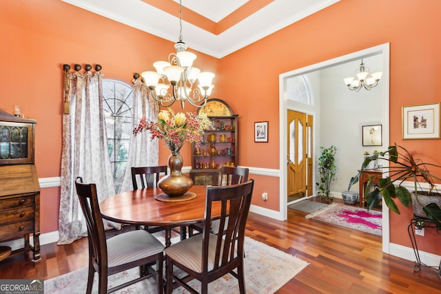 dining room with a chandelier, ornamental molding, wood finished floors, and baseboards