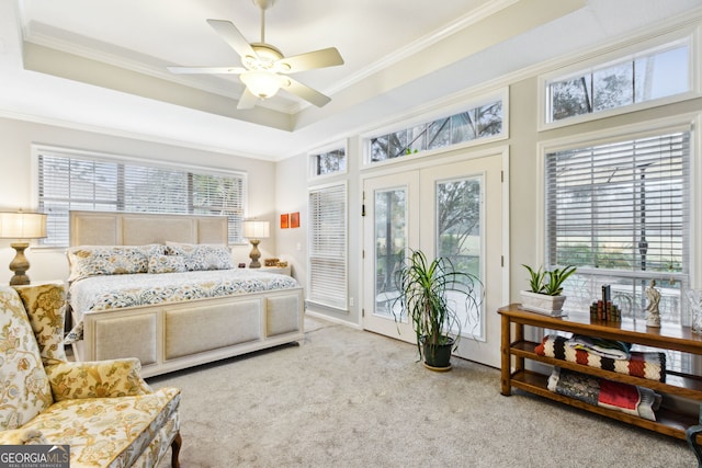 bedroom featuring access to outside, ornamental molding, multiple windows, and a raised ceiling