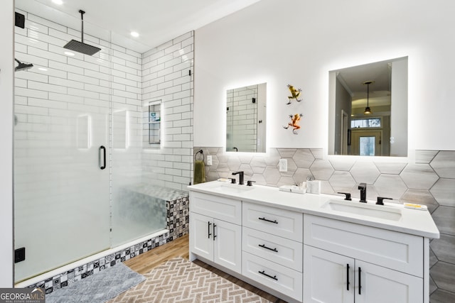 bathroom with a stall shower, a sink, tile walls, and double vanity