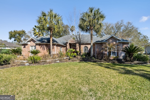 ranch-style home featuring a front yard and brick siding