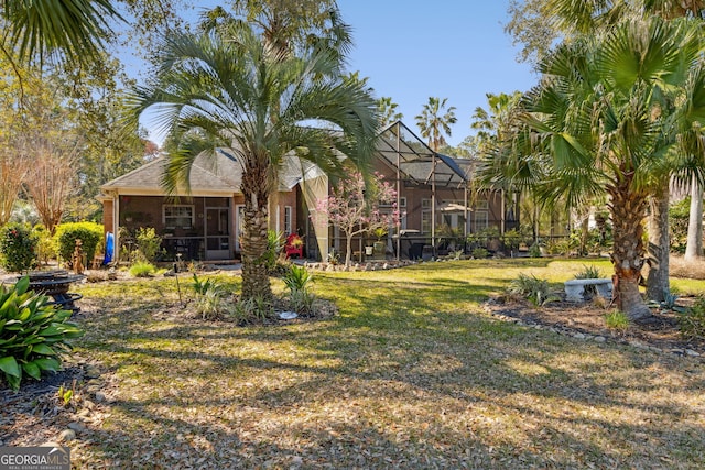 rear view of property featuring a yard and a lanai