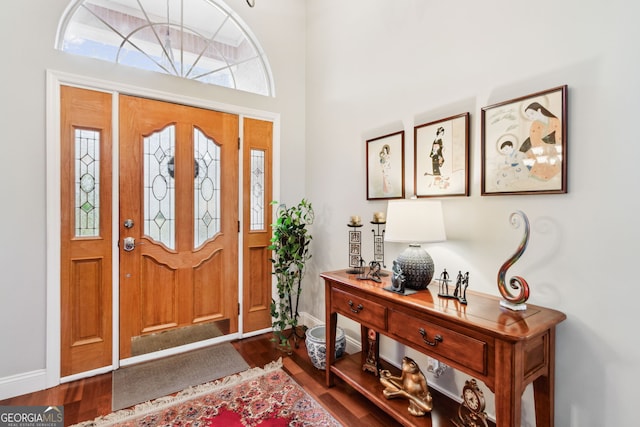 foyer featuring dark wood-type flooring and baseboards