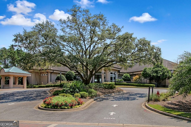 view of front facade with a gazebo, curved driveway, and stucco siding